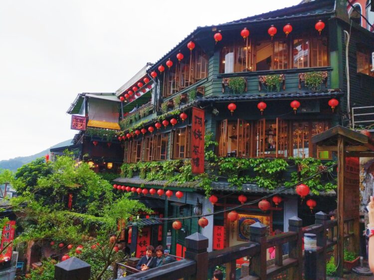 A photo of a back building covered in red lanterns