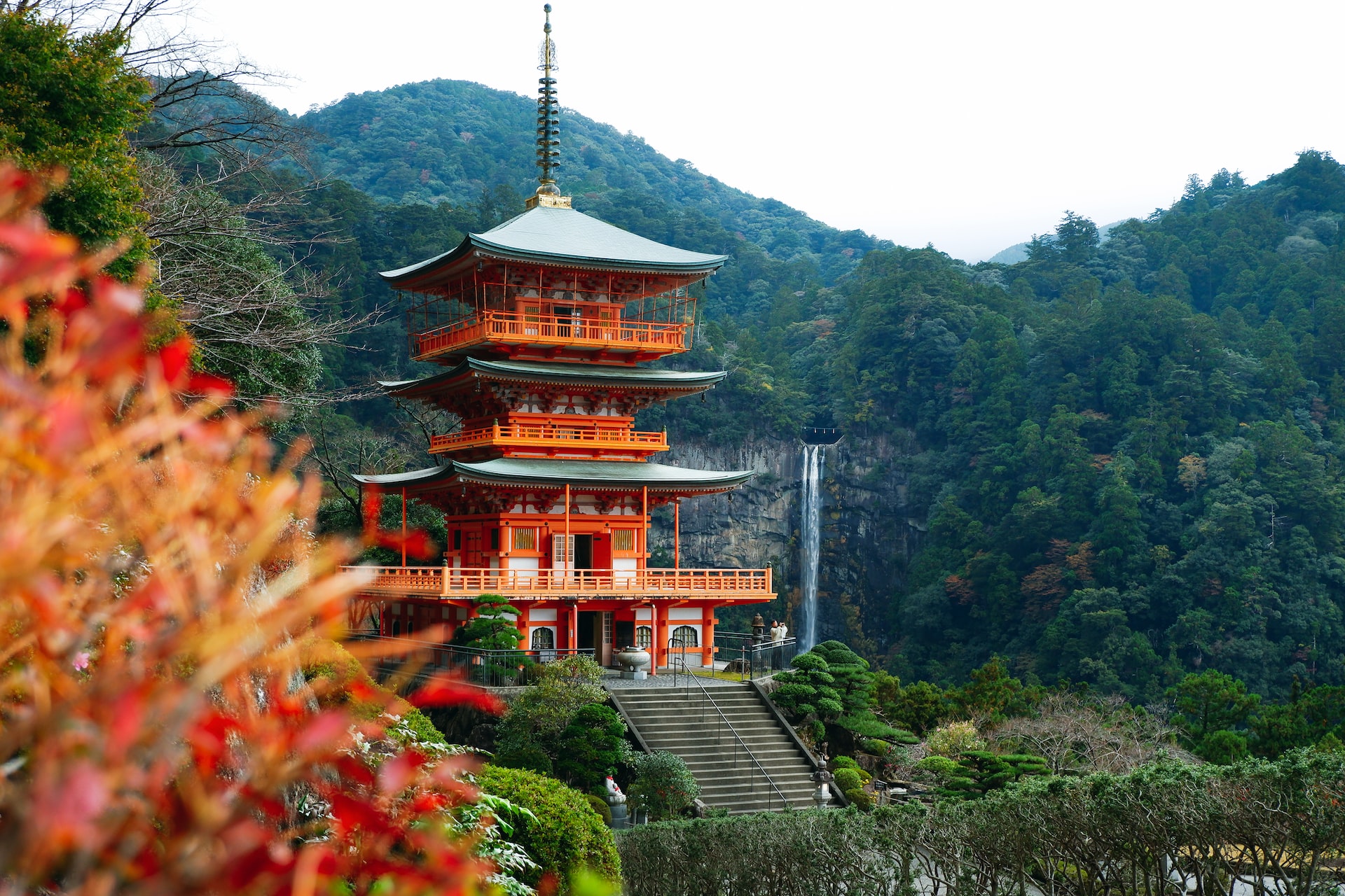 A photo of a vermillion three-tiered pagoda at the Kumano Nachi Waterfall in Japan