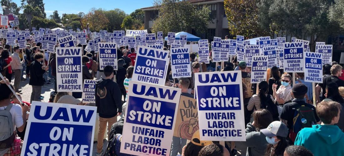 TAs at UCSB on strike, holding signs "UAW on Strike, Unfair Labor Practice"