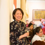 Woman smiling for the camera holding a wine glass, black bamboo blouse