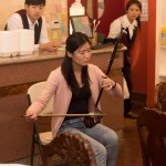 Woman in pink cardigan playing an instrument